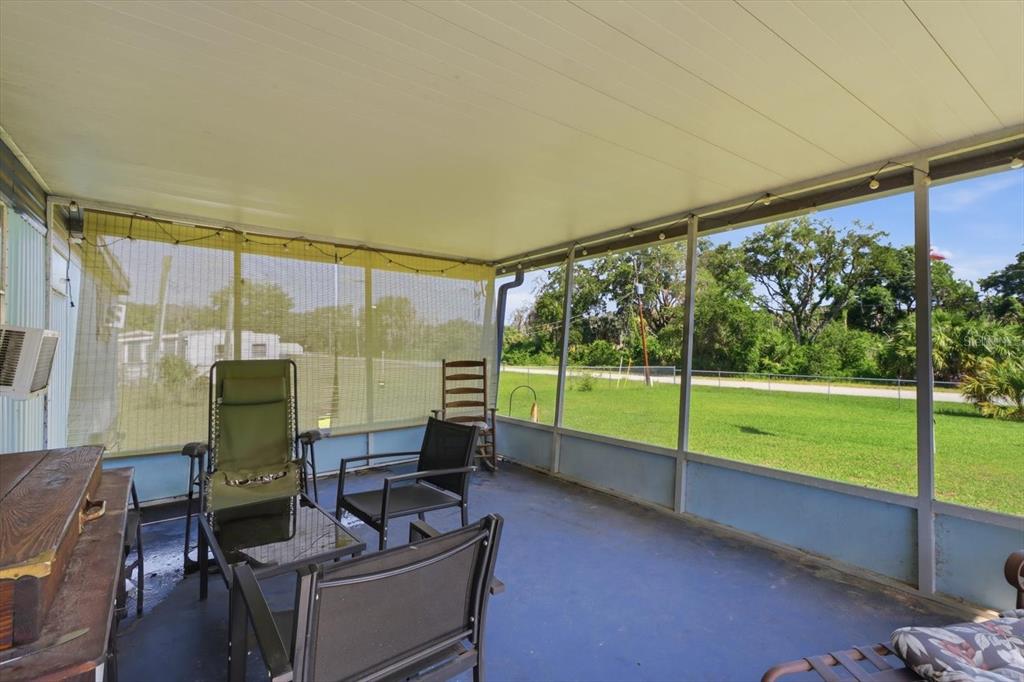 A covered screened-in porch with blue flooring, outdoor furniture, and a view of a lawn — 4610 E AMHERST STREET, HERNANDO, FL