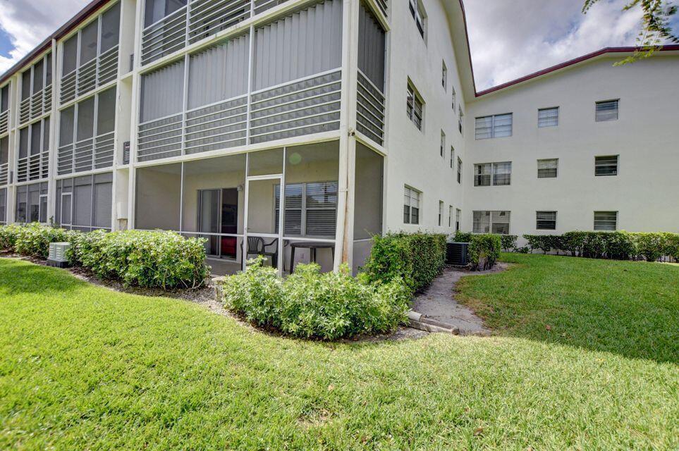 An empty room with beige tile flooring, a ceiling fan, and a glass-paneled door — 137 Fanshaw D, Boca Raton FL 33434, BOCA RATON, FL