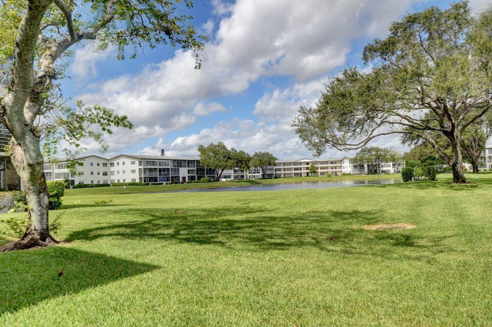 An empty room with beige walls, tile flooring, a ceiling fan, and a chandelier — 137 Fanshaw D, Boca Raton FL 33434, BOCA RATON, FL