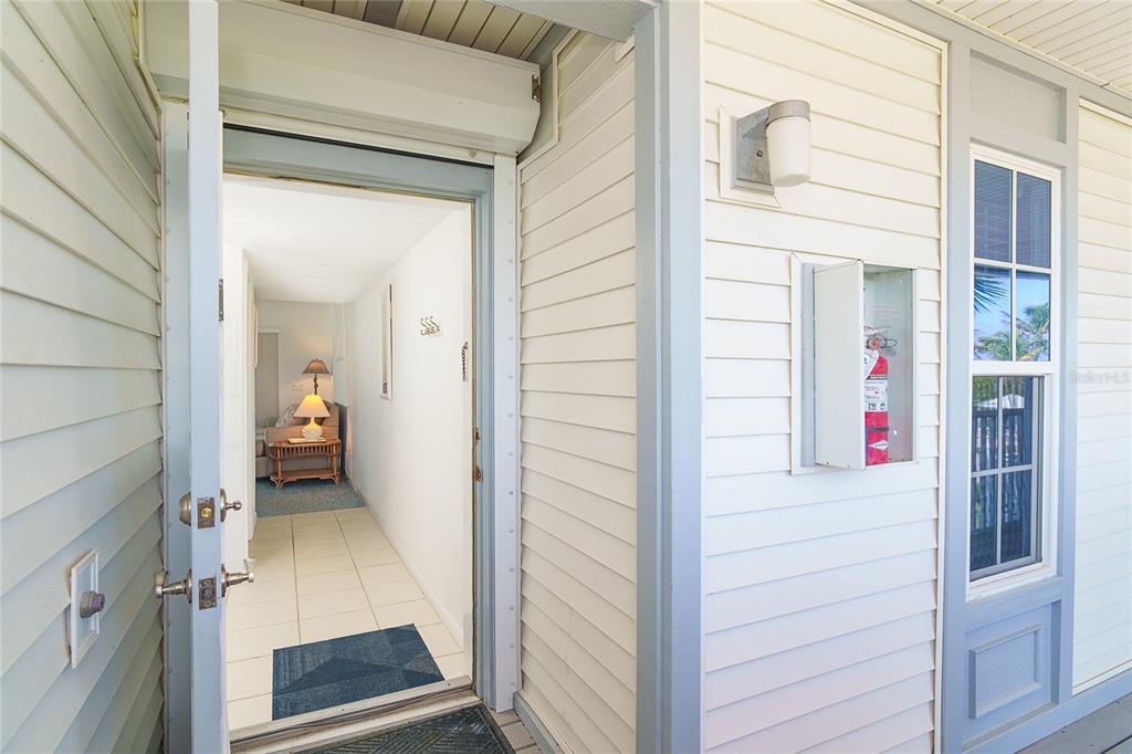 An open doorway reveals a tiled hallway leading to a living area with a lamp — 7438 PALM ISLAND DRIVE UNIT 3721, PLACIDA, FL