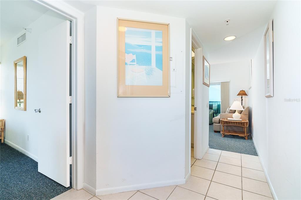 A hallway with tile flooring leads to a living area with carpet and a balcony — 7438 PALM ISLAND DRIVE UNIT 3721, PLACIDA, FL