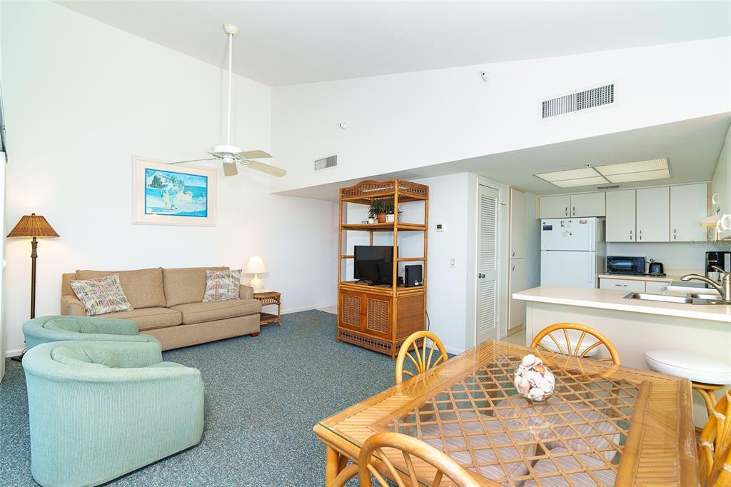 A living and dining area with a vaulted ceiling, carpeted floors, and a kitchen island — 7438 PALM ISLAND DRIVE UNIT 3721, PLACIDA, FL