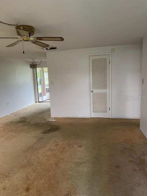 A room with beige carpet, a ceiling fan, and a white door with louvers — 21084 QUESADA AVENUE, PORT CHARLOTTE, FL