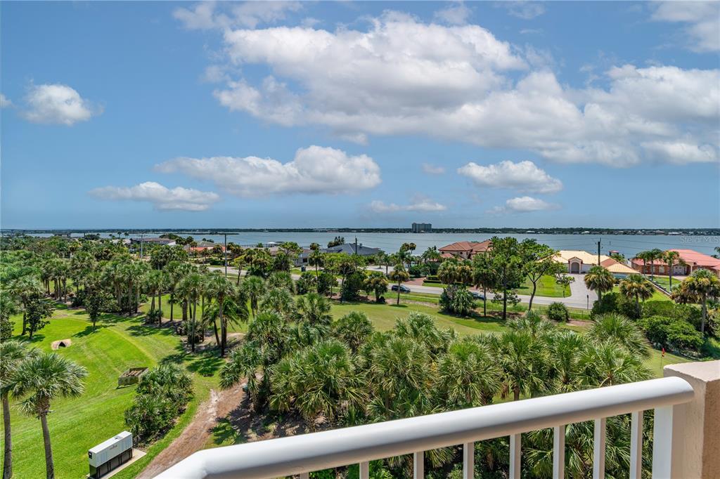 An elevated view of a golf course, palm trees, and a body of water — 3 OCEANS WEST BOULEVARD UNIT 6C4, DAYTONA BEACH SHORES, FL