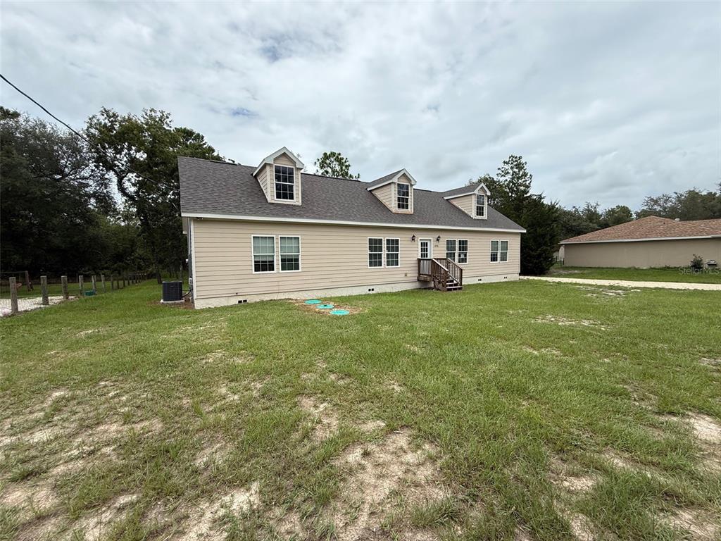 A beige two-story house with three dormer windows and a small wooden back deck — 11970 OSPREY AVENUE, WEEKI WACHEE, FL