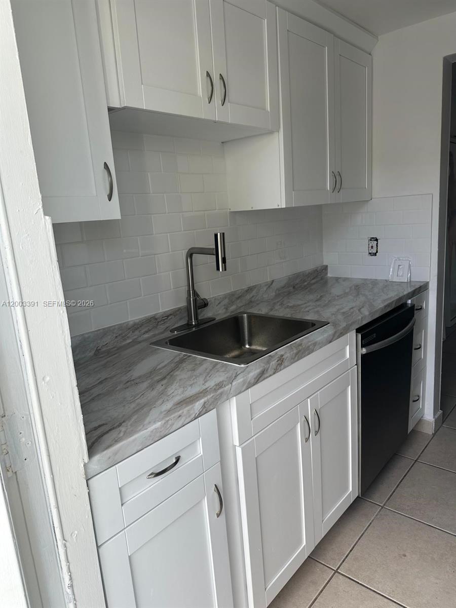 A kitchen features white shaker cabinets, a marble-patterned countertop, and a stainless steel sink — 360 Meridian Ave # 4C, Miami Beach FL 33139, MIAMI BEACH, FL