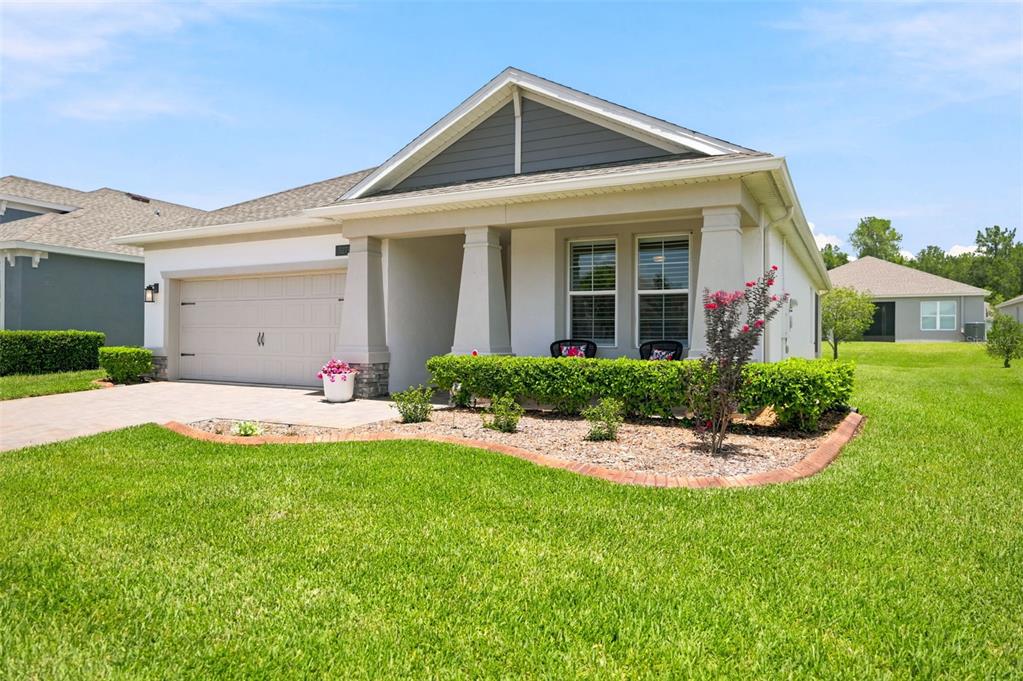 A single-story suburban house with a two-car garage, covered porch, and landscaped front yard — 5271 CAPPLEMAN LOOP, BROOKSVILLE, FL