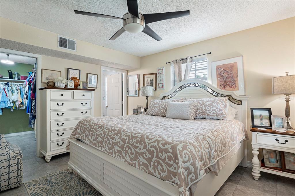 A bedroom features a white bed frame, a matching dresser, and a walk-in closet — 7067 JARVIS ROAD, SARASOTA, FL