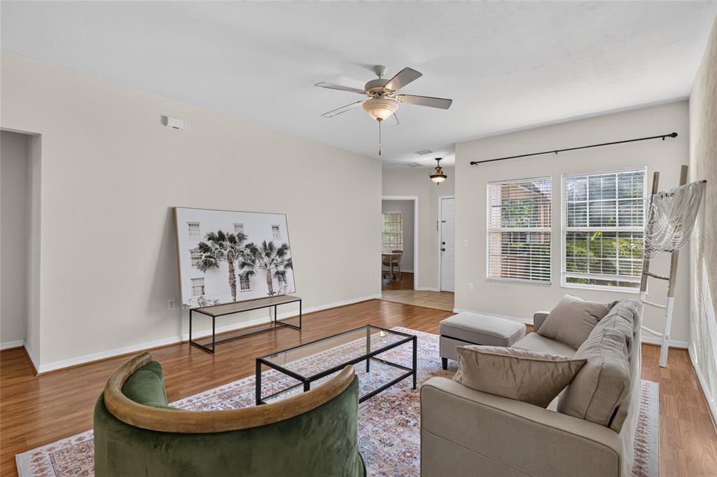 A living room features hardwood floors, a ceiling fan, a sofa, and a green armchair — 7852 SW 84TH WAY, GAINESVILLE, FL