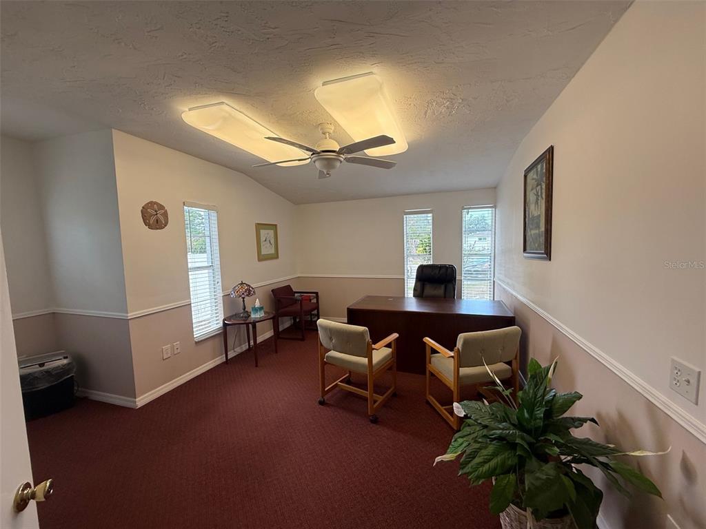 A home office features red carpeting, a wooden desk, three chairs, and a ceiling fan — 5422 TROUBLE CREEK ROAD, NEW PORT RICHEY, FL