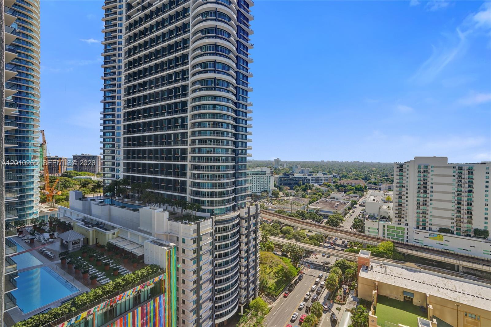 An elevated view of a modern high-rise building with balconies and an outdoor pool — 1250 S Miami Ave # 2103, Miami FL 33130, MIAMI, FL