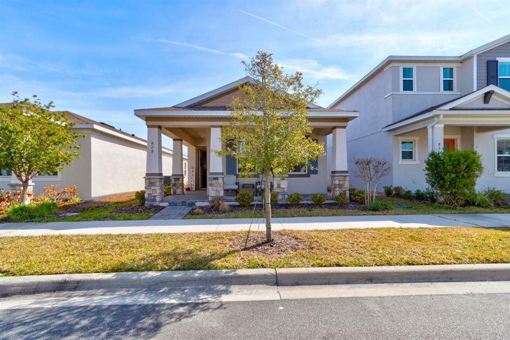 A single-story house with a covered front porch, stone columns, and a small front yard — 828 MIDDLETON STREET, DEBARY, FL