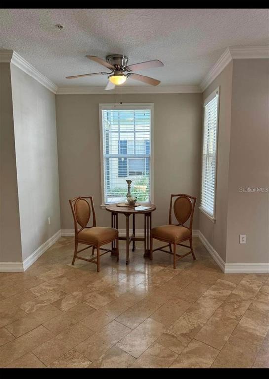A dining nook features a small round table, two chairs, tile flooring, and a ceiling fan — 611 CAMPUS STREET UNIT 180, CELEBRATION, FL