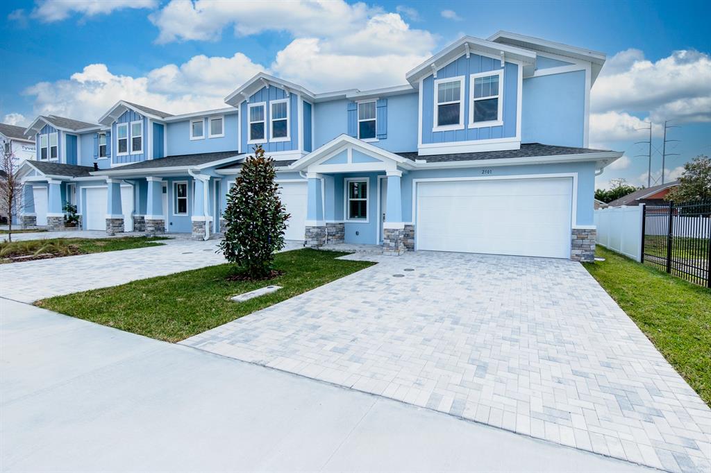 A light blue two-story townhouse exterior with a white garage and a paved driveway — 2500 MARIO WAY, CLEARWATER, FL