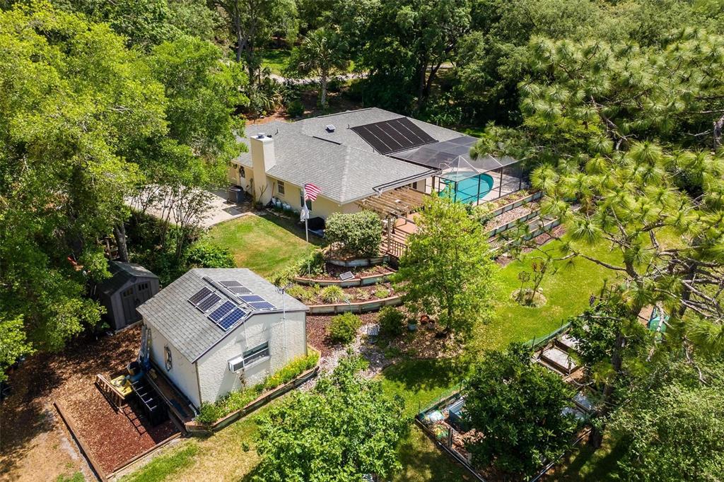 An aerial view shows a house with a pool, solar panels, and a detached garage — 4024 EAGLE RIDGE ROAD, FRUITLAND PARK, FL