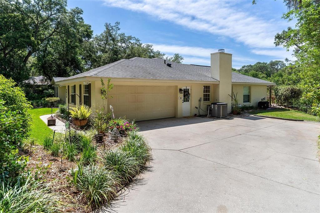A single-story house with a beige exterior, a two-car garage, and a concrete driveway — 4024 EAGLE RIDGE ROAD, FRUITLAND PARK, FL