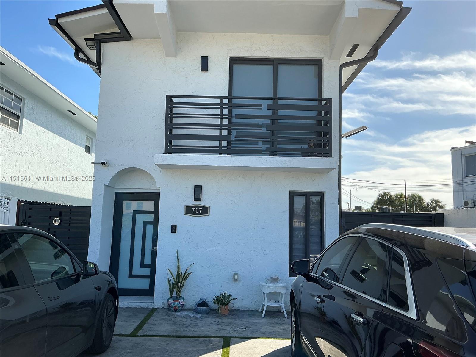 A two-story white stucco house features a black balcony railing and a modern front door — 717 Tamiami Canal Rd, Miami FL 33144, MIAMI, FL