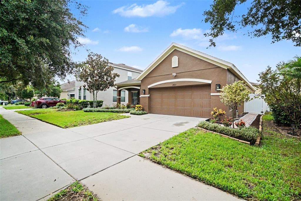 A sunroom features black leather furniture, a patterned area rug, and floor-to-ceiling windows — 2722 WINGLEWOOD CIRCLE, LUTZ, FL