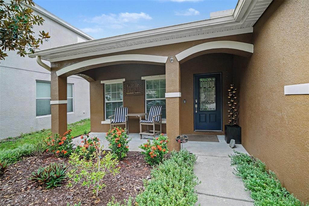A large outdoor swimming pool features a water slide, palm trees, and blue umbrellas — 2722 WINGLEWOOD CIRCLE, LUTZ, FL