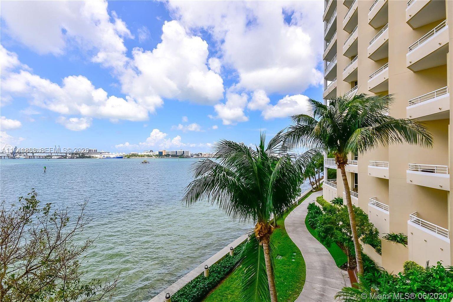 A view from a balcony overlooking a bay, a palm tree, and a building exterior — 888 Brickell Key Dr # 600, Miami FL 33131, MIAMI, FL