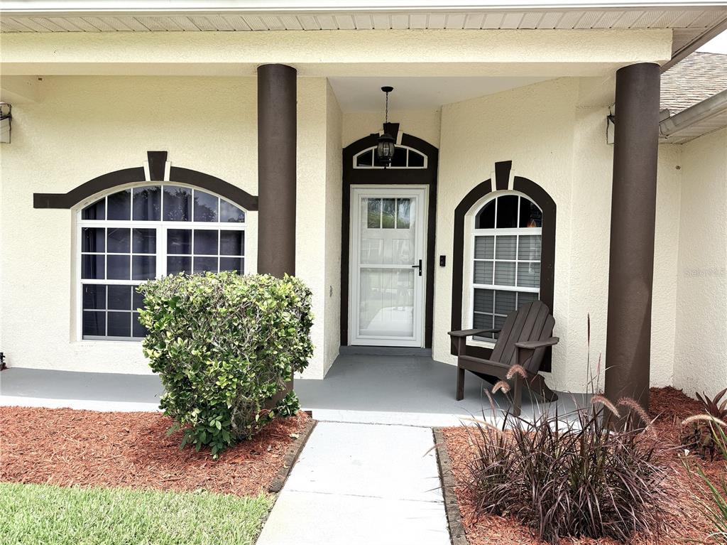 A single-story house with a tan exterior, brown roof, and palm trees in the front yard — 3338 GATOR BAY CREEK BOULEVARD, ST CLOUD, FL