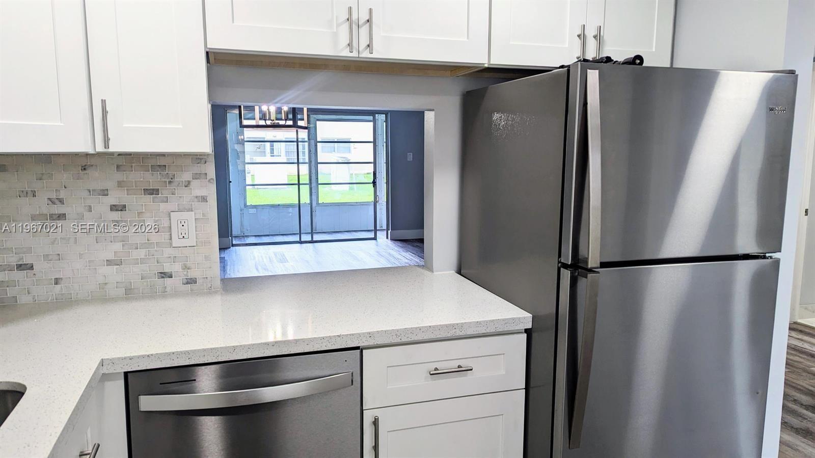 An empty dining area features light gray walls, wood-look flooring, and a modern lantern-style chandelier — 7600 NW 5th Pl # 108, Margate FL 33063, MARGATE, FL