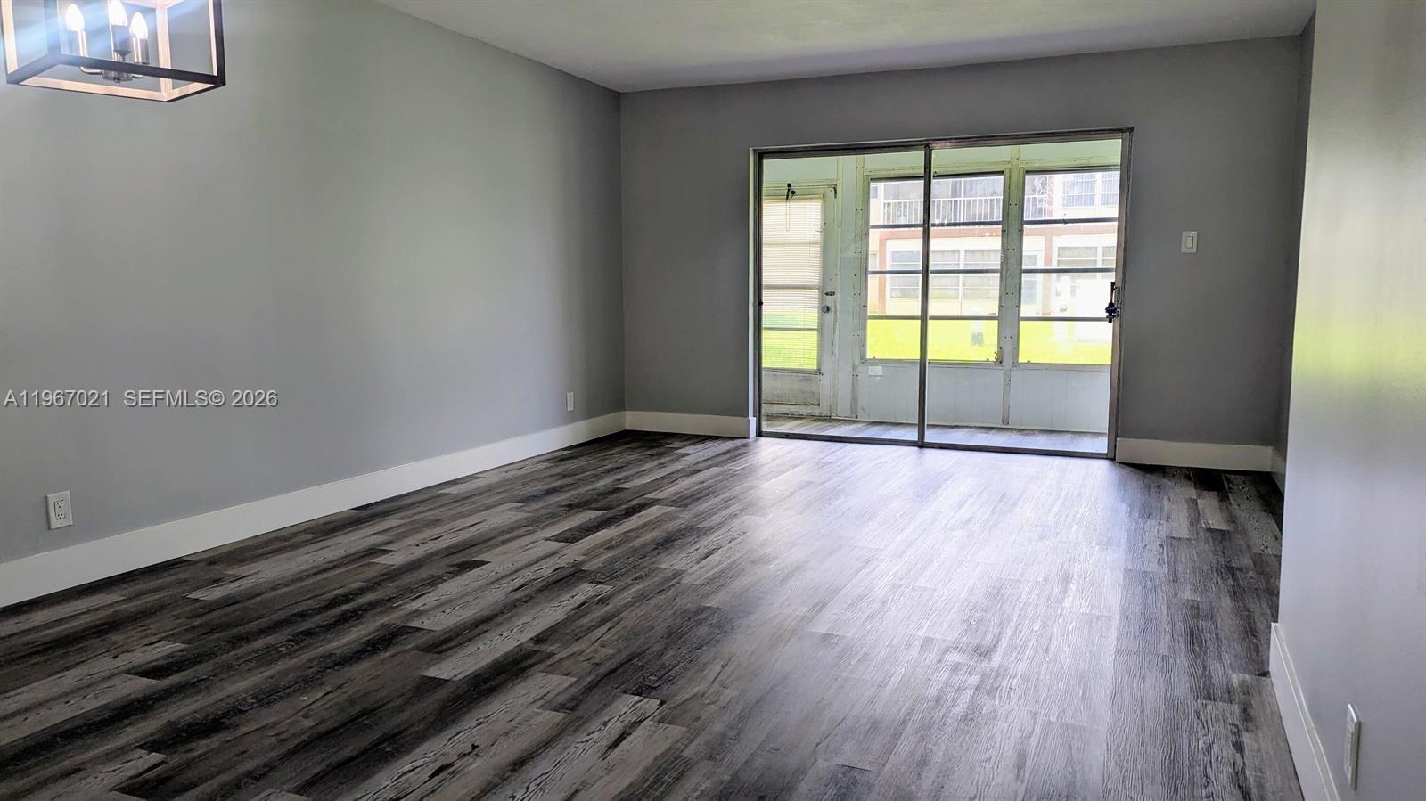 A bedroom features a bed with a striped comforter, two windows, and wood-look flooring — 7600 NW 5th Pl # 108, Margate FL 33063, MARGATE, FL