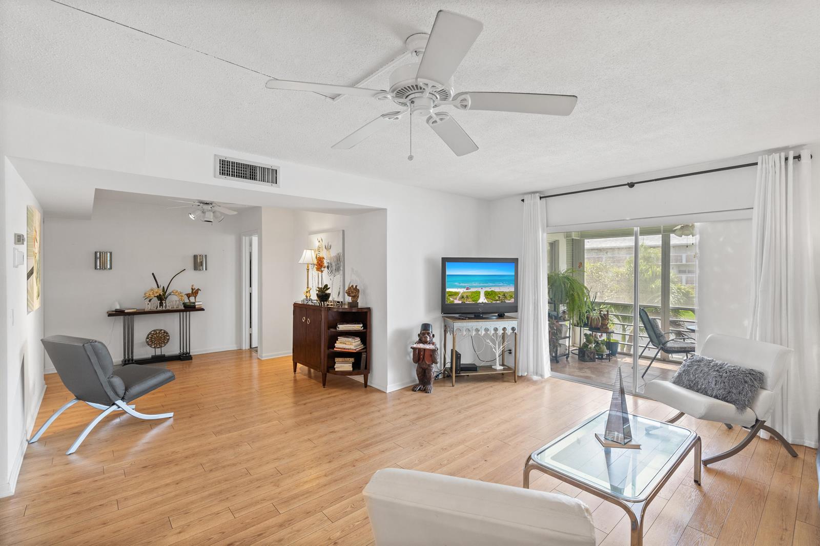A living room with light wood flooring, a ceiling fan, and a sliding glass door — 25 SE 13th Street # B3, Boca Raton FL 33432, BOCA RATON, FL