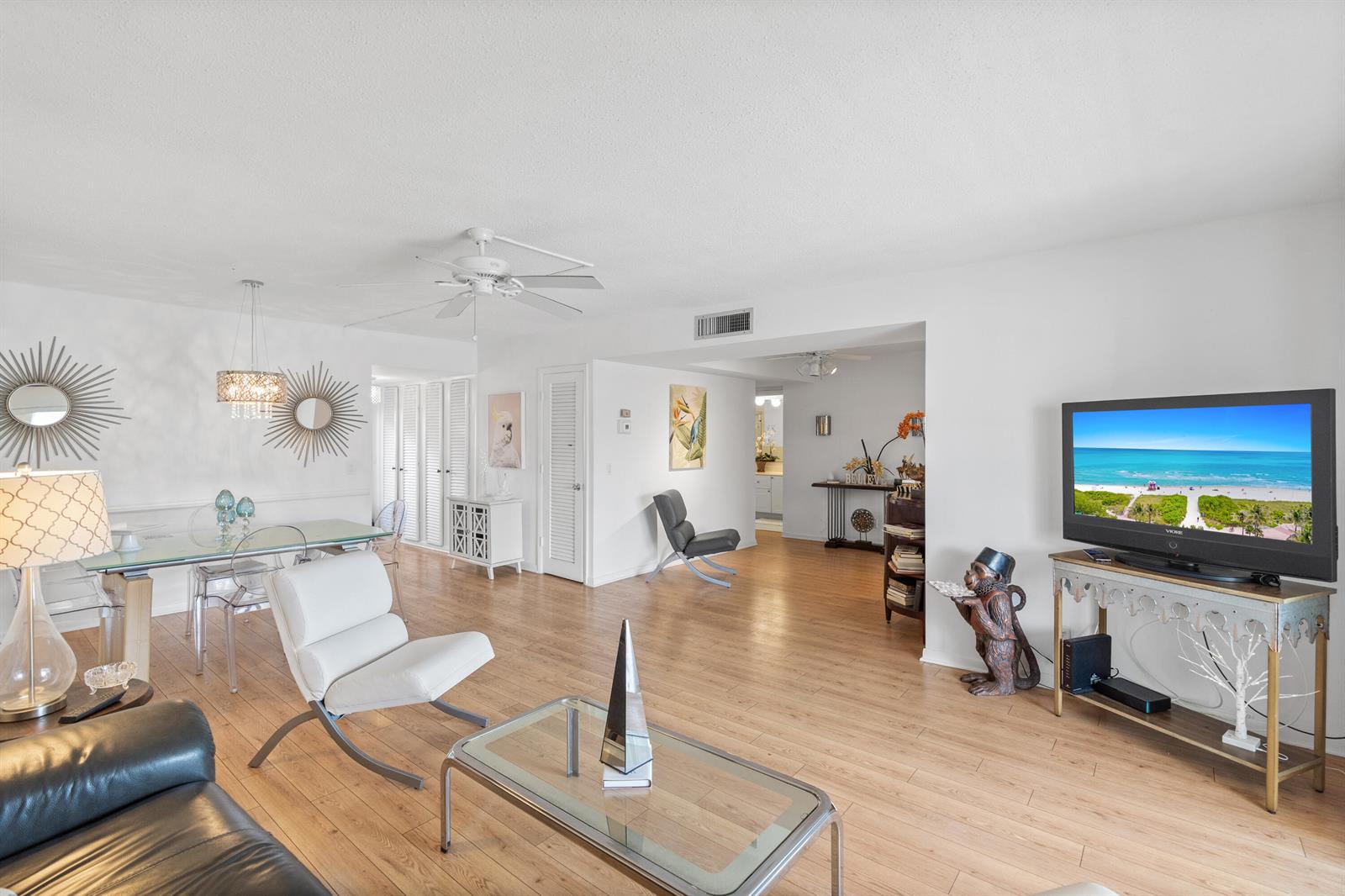 A living and dining area features light wood flooring, white walls, and a television console — 25 SE 13th Street # B3, Boca Raton FL 33432, BOCA RATON, FL