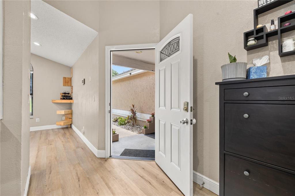 A concrete walkway leads to a white front door flanked by tiered concrete planters — 6613 CHANTRY STREET, ORLANDO, FL