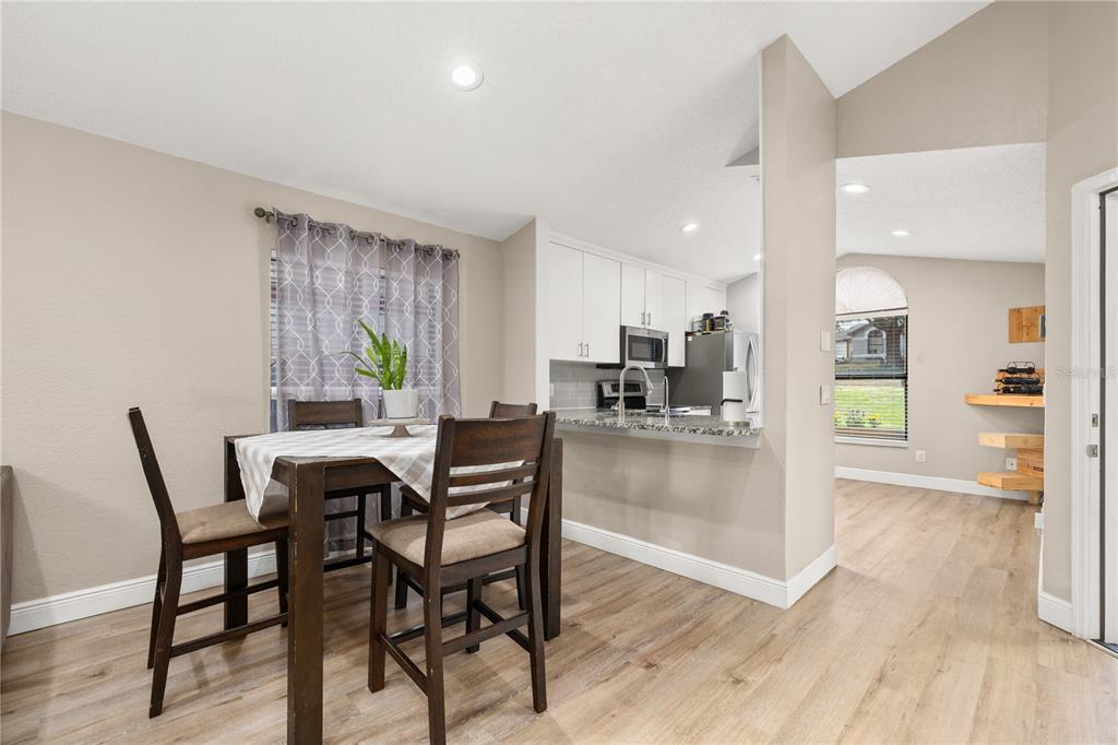 An entryway with light wood flooring, a white front door, and a dark storage cabinet — 6613 CHANTRY STREET, ORLANDO, FL
