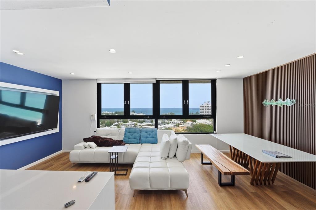 A living room features a white sectional sofa, a dining table with a bench, and ocean views — INGA 1 N COSTAMAR CONDOMINIUM UNIT PH, SAN JUAN, PR