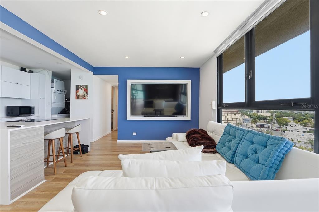 A living room with a blue accent wall, white sofa, and kitchen island with bar stools — INGA 1 N COSTAMAR CONDOMINIUM UNIT PH, SAN JUAN, PR