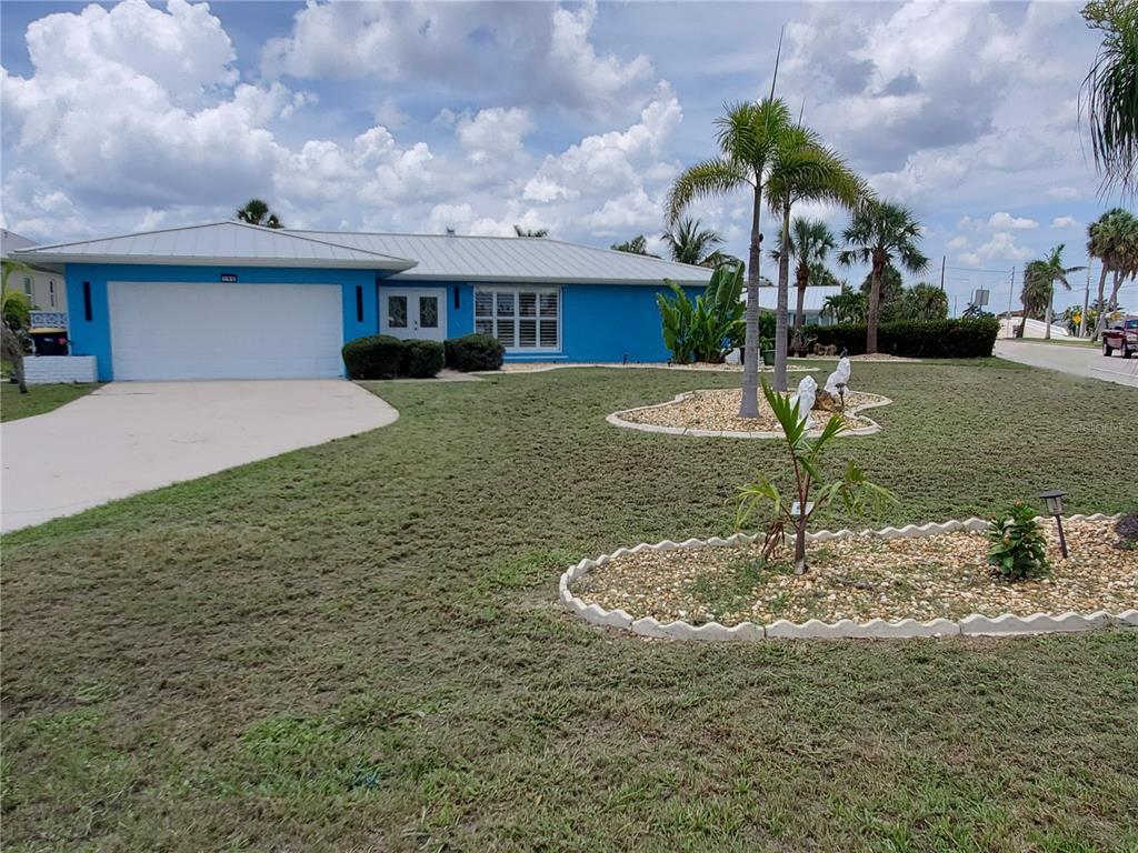 A blue single-story house with a white garage door and a metal roof — 190 CASA LANE, PUNTA GORDA, FL