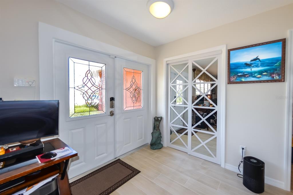 An entryway features a double front door, mirrored closet doors, and light-colored tile flooring — 190 CASA LANE, PUNTA GORDA, FL