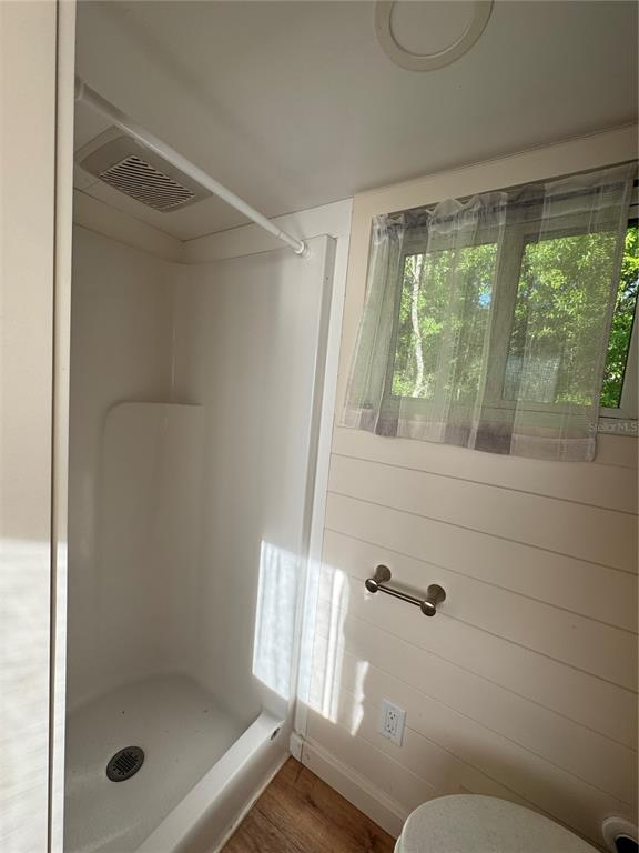 A bathroom features a shower stall, a window with a curtain, and white shiplap walls — NW 4TH STREET, OCALA, FL