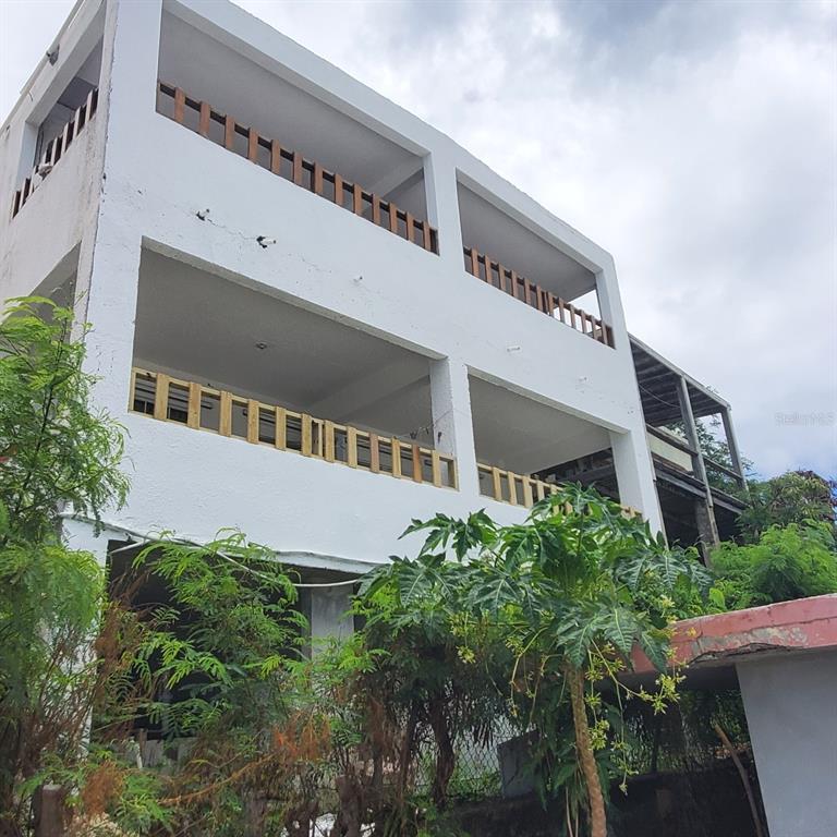A three-story white concrete building features open-air balconies with wooden railings on the upper levels — 27 WILLIAM FONT STREET, CULEBRA, PR