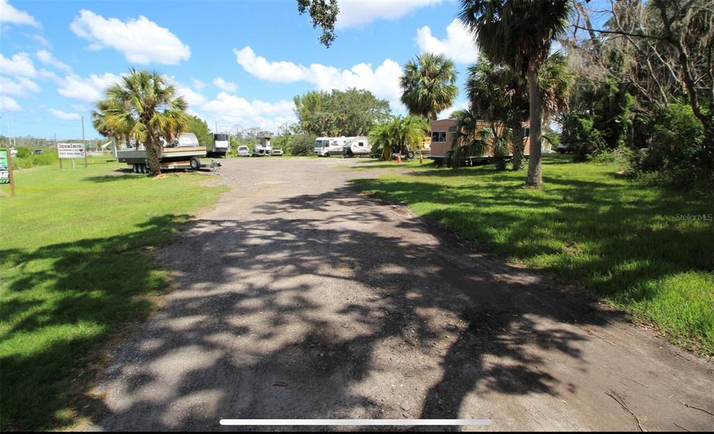 A gravel driveway leads to a parking area with several recreational vehicles and palm trees — 1322 N PINELLAS AVENUE, TARPON SPRINGS, FL