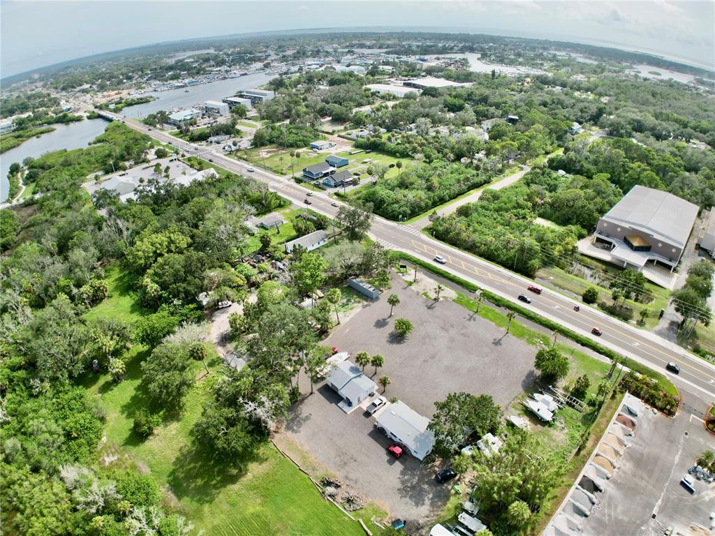 An aerial view shows a commercial property with small buildings, a gravel lot, and nearby road — 1322 N PINELLAS AVENUE, TARPON SPRINGS, FL