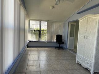 A sunroom with tile flooring, vertical blinds, a ceiling fan, and a white wicker armoire — 5343 NW 4th Terrace, Deerfield Beach FL 33064, DEERFIELD BEACH, FL