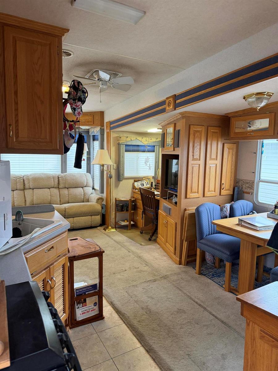 An interior view of a recreational vehicle featuring a living area, dining space, and kitchen — 5240 SE 67th Avenue SE, Okeechobee FL 34974, OKEECHOBEE, FL