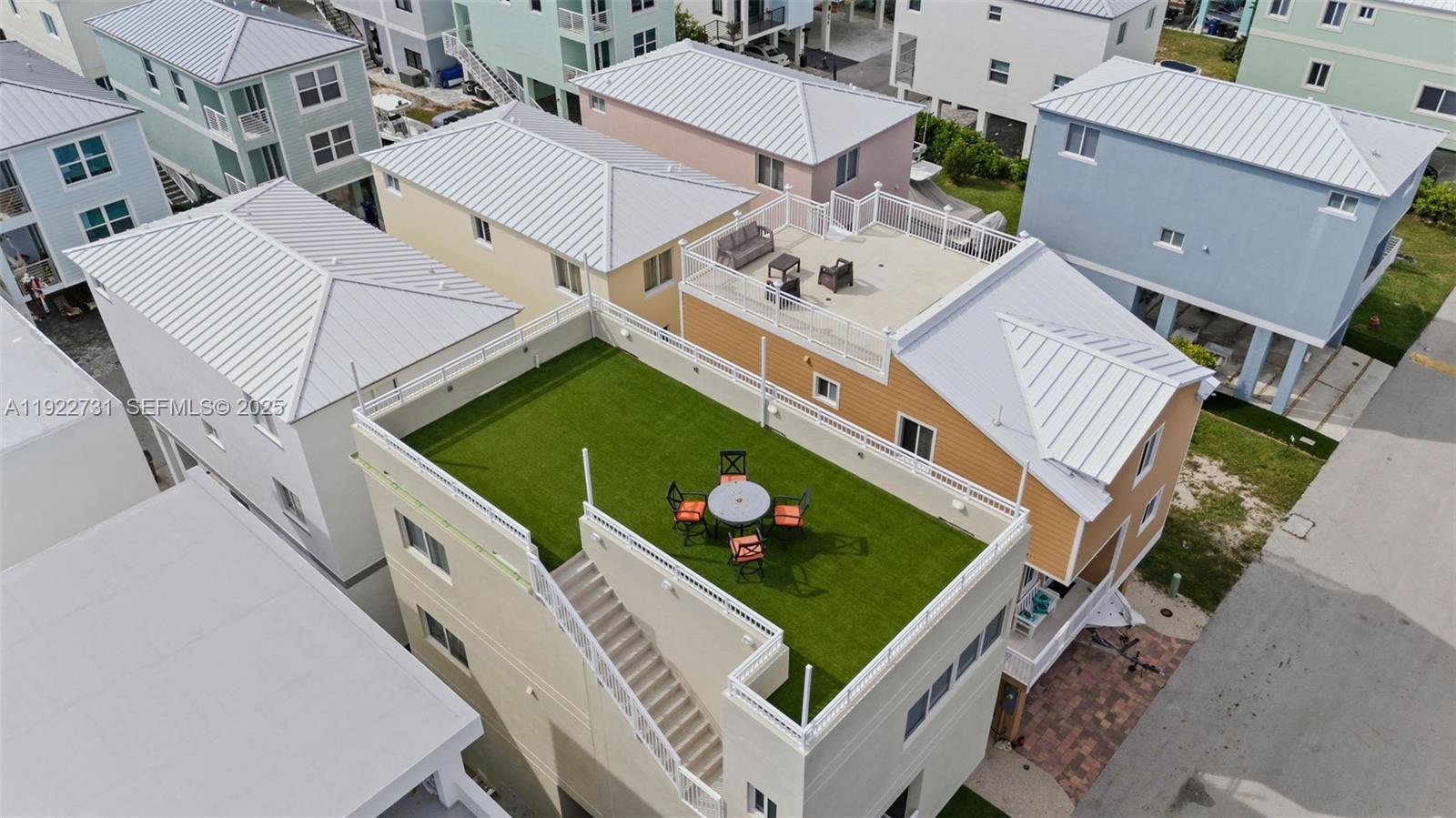 An aerial view shows several houses with rooftop decks, including one with artificial turf — 94825 Overseas hwy 276, Key Largo FL 33037, KEY LARGO, FL