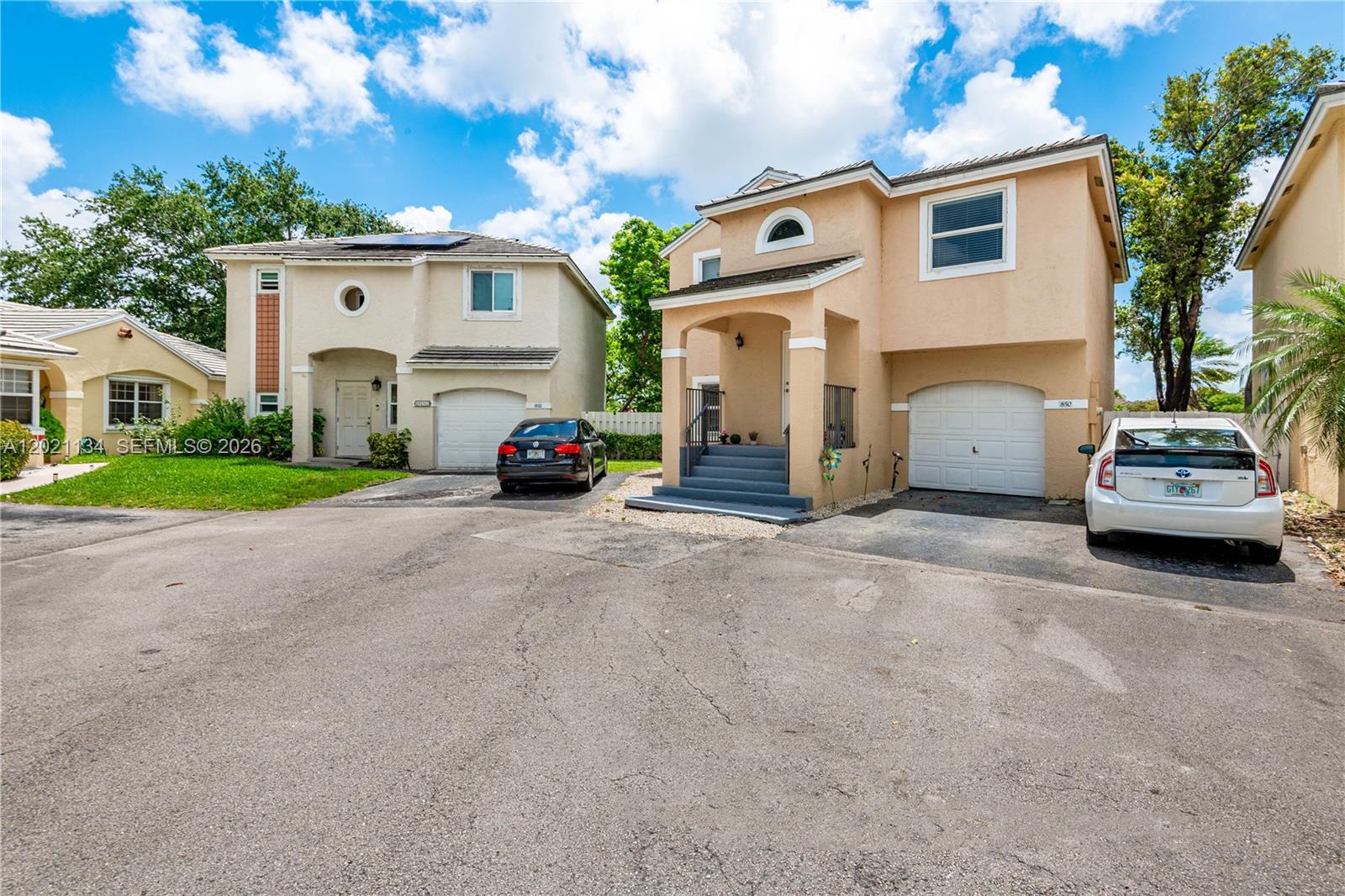 Two two-story suburban houses with attached garages sit side-by-side on a paved driveway — 850 NW 98th Ave, Plantation FL 33324, PLANTATION, FL