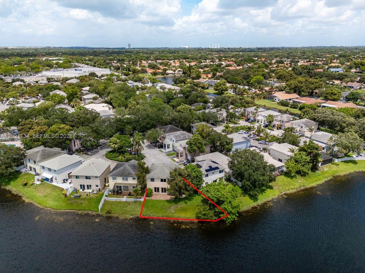 An aerial view shows a residential house with a red-outlined backyard bordering a lake — 850 NW 98th Ave, Plantation FL 33324, PLANTATION, FL