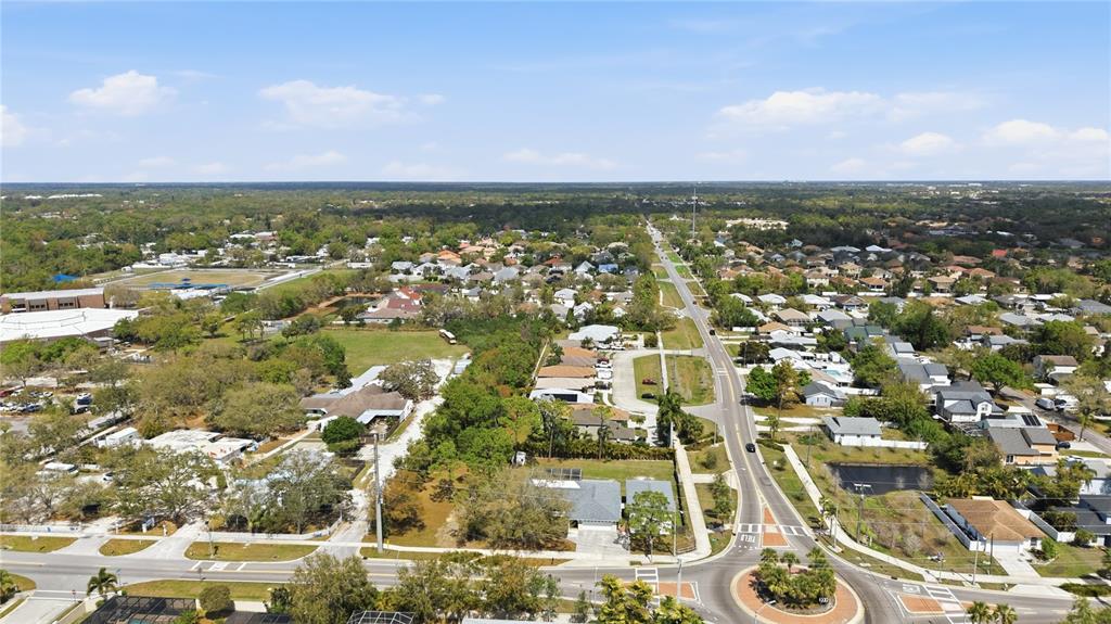 An aerial view shows a residential neighborhood with a roundabout and a long road — 5251 ASHTON ROAD, SARASOTA, FL