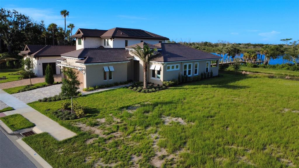 An aerial view of a two-story house with a tile roof and a waterfront backyard — 4 CORONADO ROAD, FLAGLER BEACH, FL