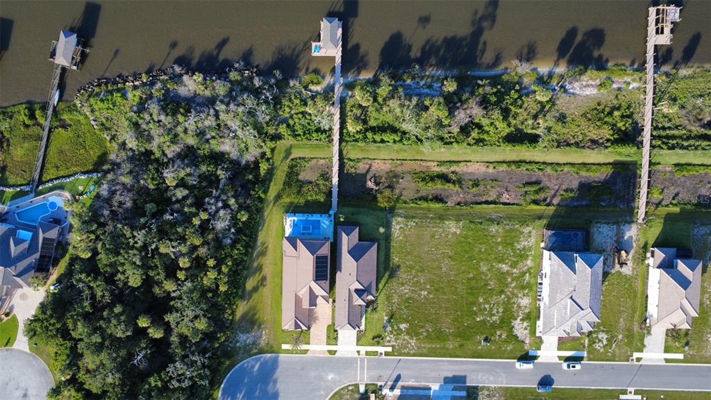An aerial view shows three waterfront houses with private docks and swimming pools — 4 CORONADO ROAD, FLAGLER BEACH, FL
