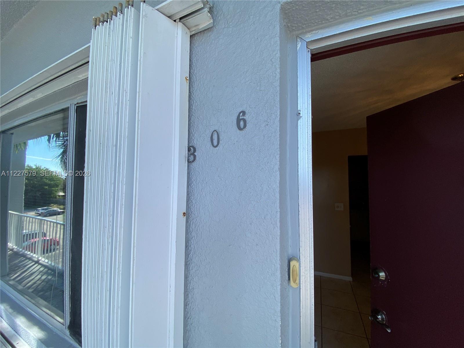 The exterior entrance of a unit features a door, a window, and the number 306 — 6289 Lear Dr # 306, Lake Worth FL 33462, LAKE WORTH, FL