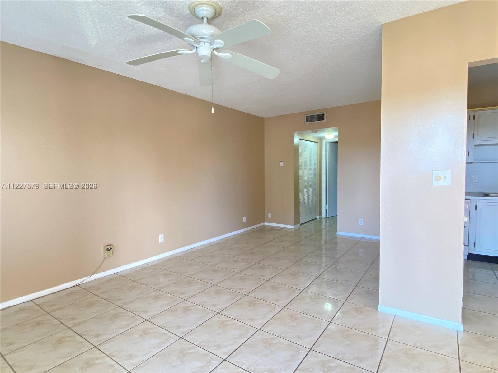 A room with beige walls, a white ceiling fan, and light-colored tiled flooring — 6289 Lear Dr # 306, Lake Worth FL 33462, LAKE WORTH, FL
