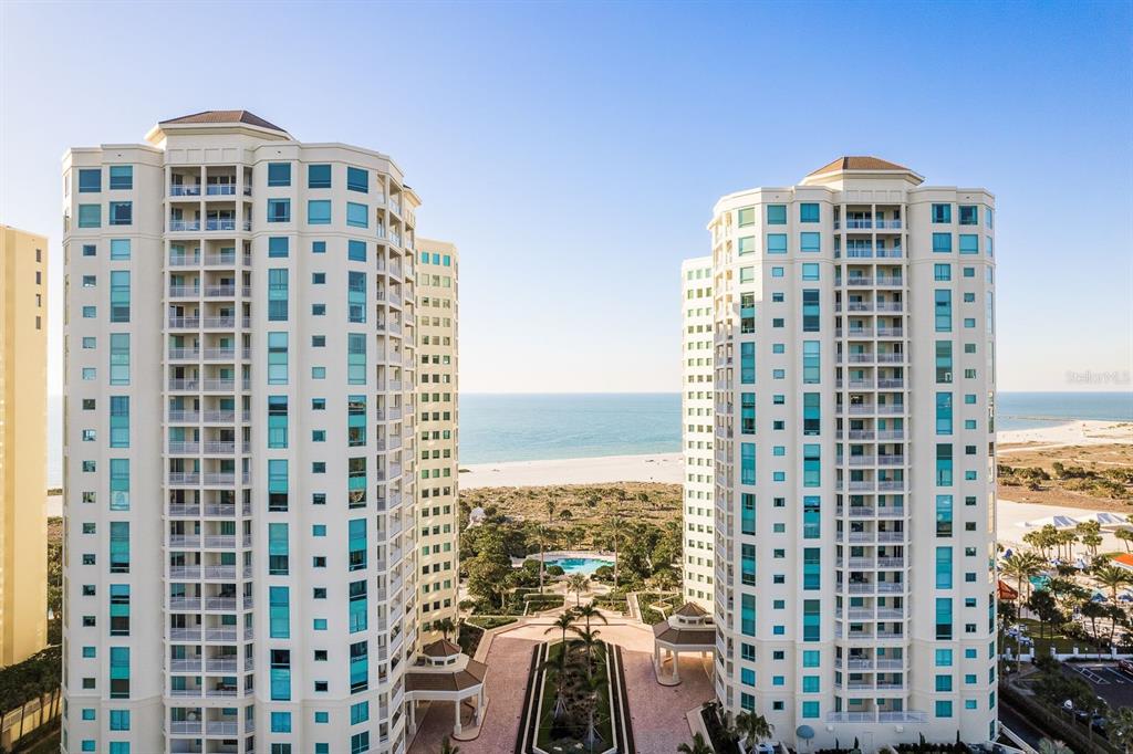 An exterior view of a tall, multi-story residential building located near a sandy beach — 1170 GULF BOULEVARD SW UNIT 1105, CLEARWATER, FL
